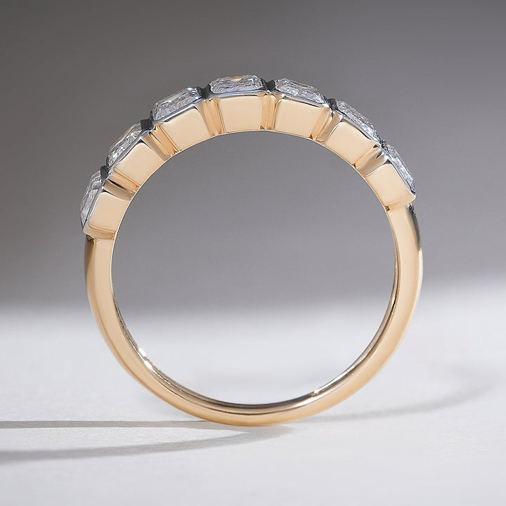 Side view of the yellow gold half eternity band, highlighting the emerald-cut diamond alignment.