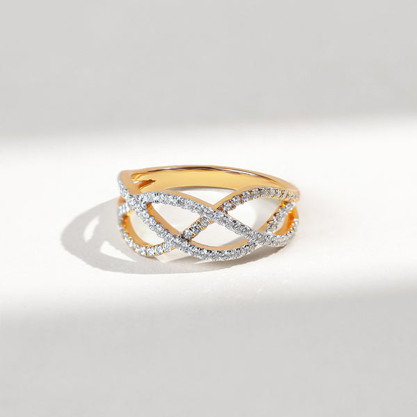 Gold and diamond interwoven patterned ring on a light gray background