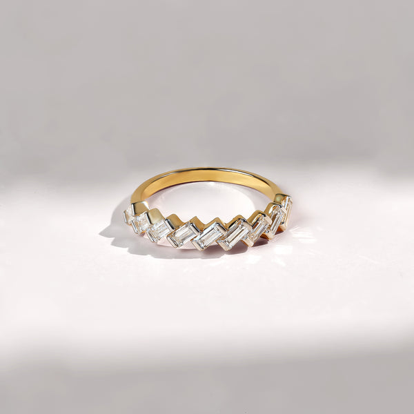Gold ring with diamond accents on a light gray background