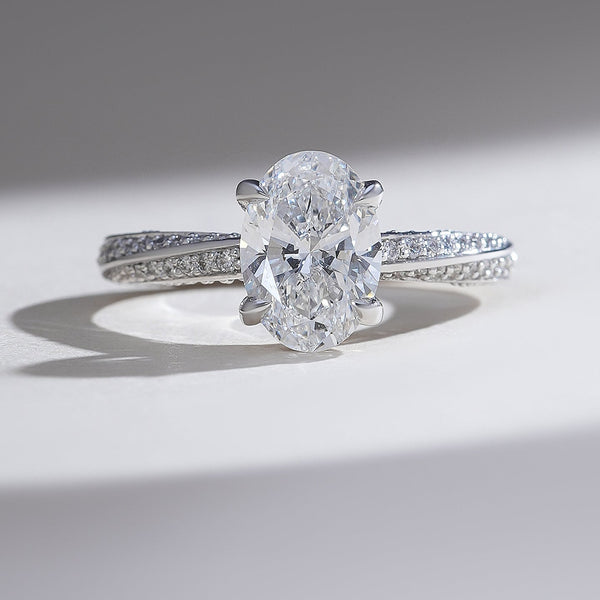 Oval-cut diamond engagement ring in white gold with pavé-set diamond band