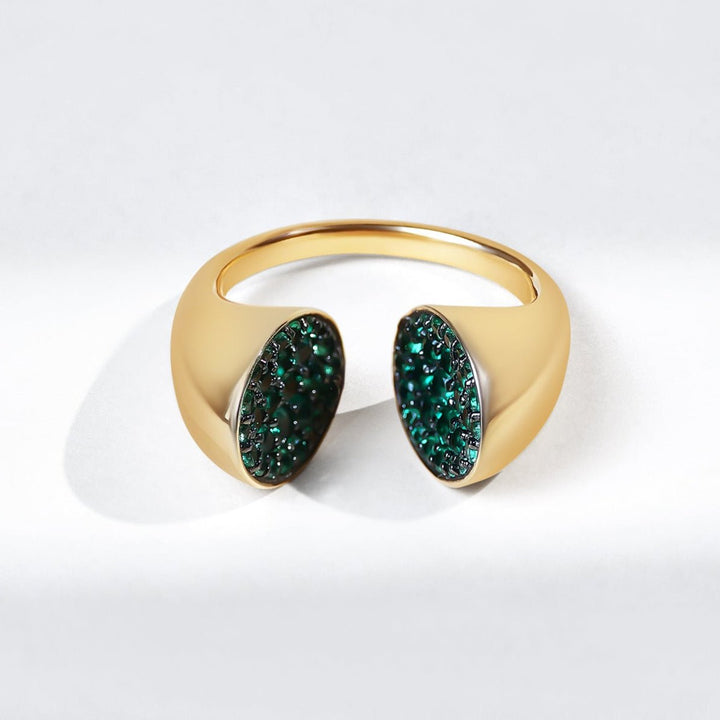 Gold ring with green gemstones on a white background