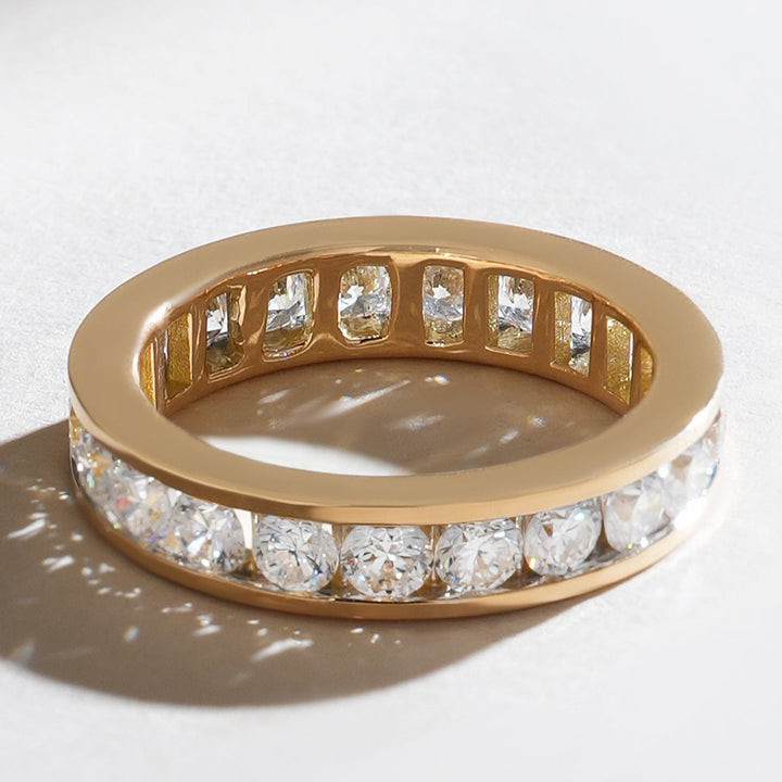 Angled view of a yellow gold 2 Ct Round Fortress Eternity Band, showcasing precision channel-set diamonds.