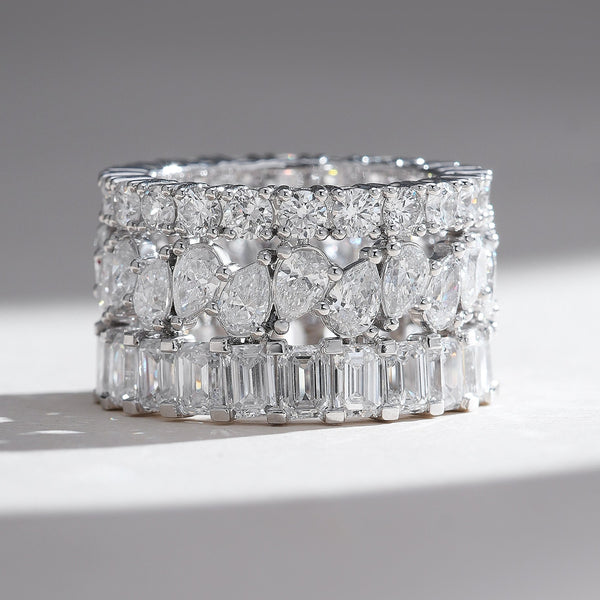Front view of wide white-gold band with three layers: pavé rounds, alternating pear and round diamonds, and vertical baguettes.