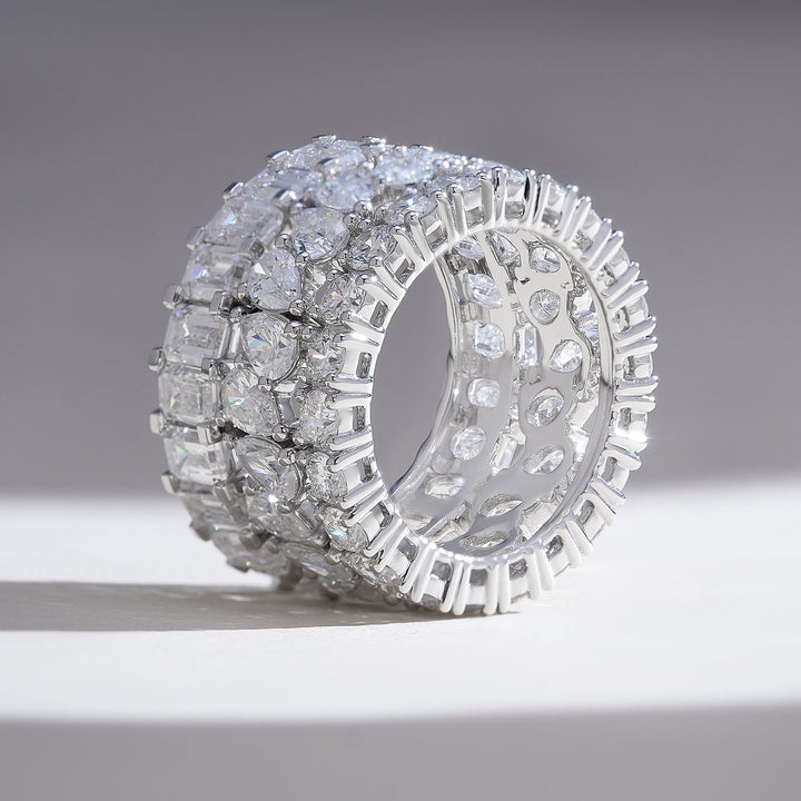 Side angle showing extra-wide profile and open gallery; tiered rows of round, pear, and baguette diamonds.