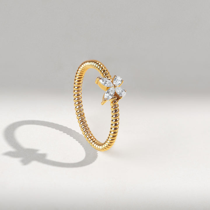 Gold ring with diamond accents on a gray background