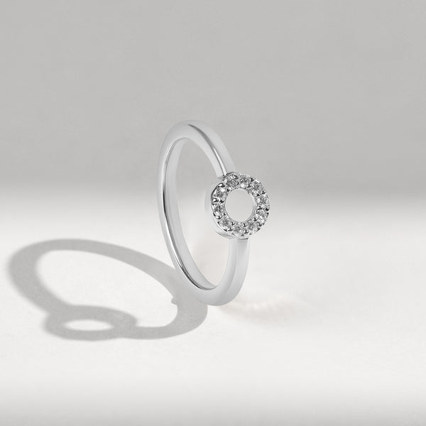 White gold ring with a small diamonds halo on a light gray background