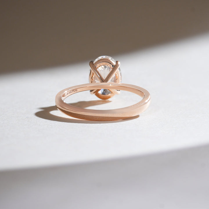 Back view of rose gold 2-carat oval diamond solitaire ring with an open gallery for maximum light.