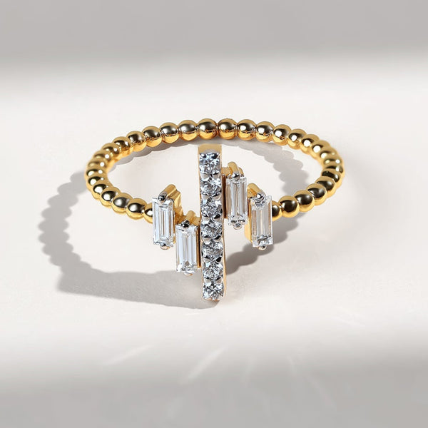 Gold ring with baguette and round diamonds on a light gray background