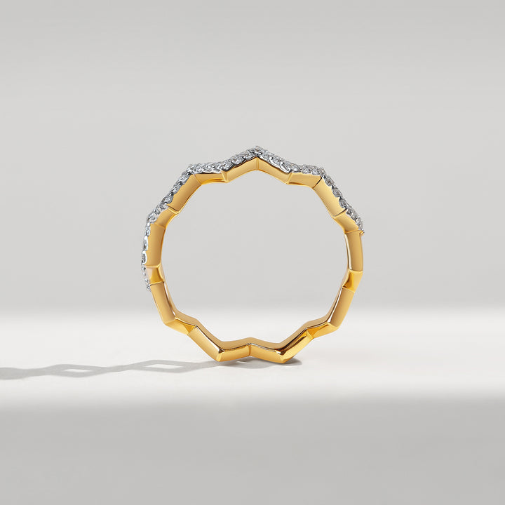 Gold ring with diamond accents on a light gray background