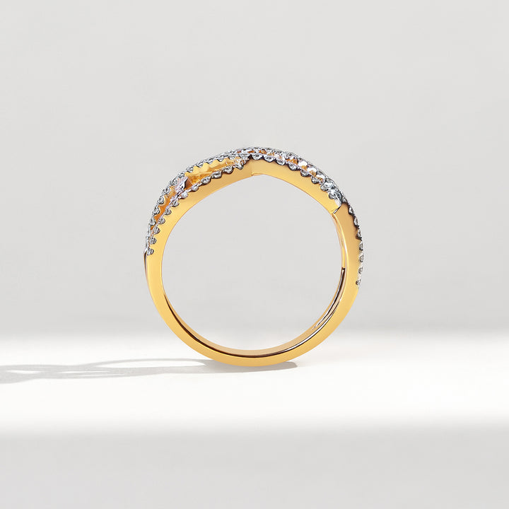 Gold ring with embedded diamonds on a light gray background