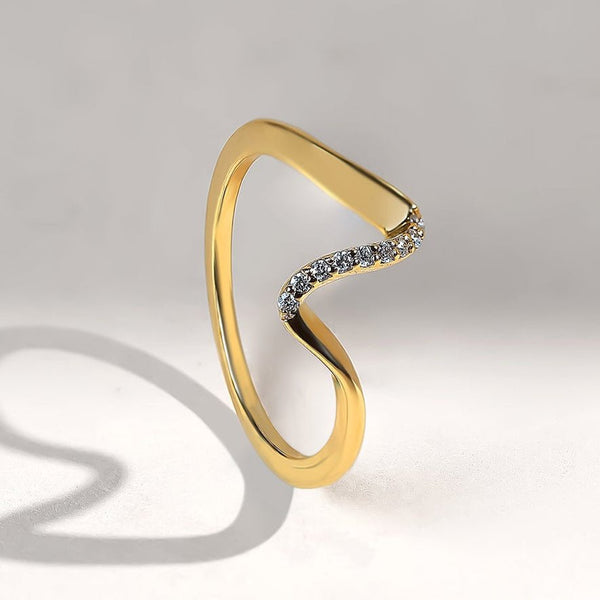 Gold ring with diamond accents on a light gray background