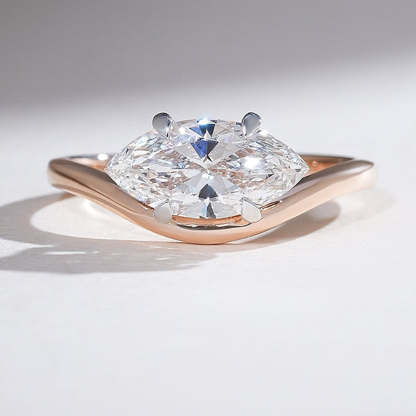 Close-up of the Aveline Marquise Solitaire Ring showcasing a marquise-cut diamond set in a rose gold band with a subtle wave design.