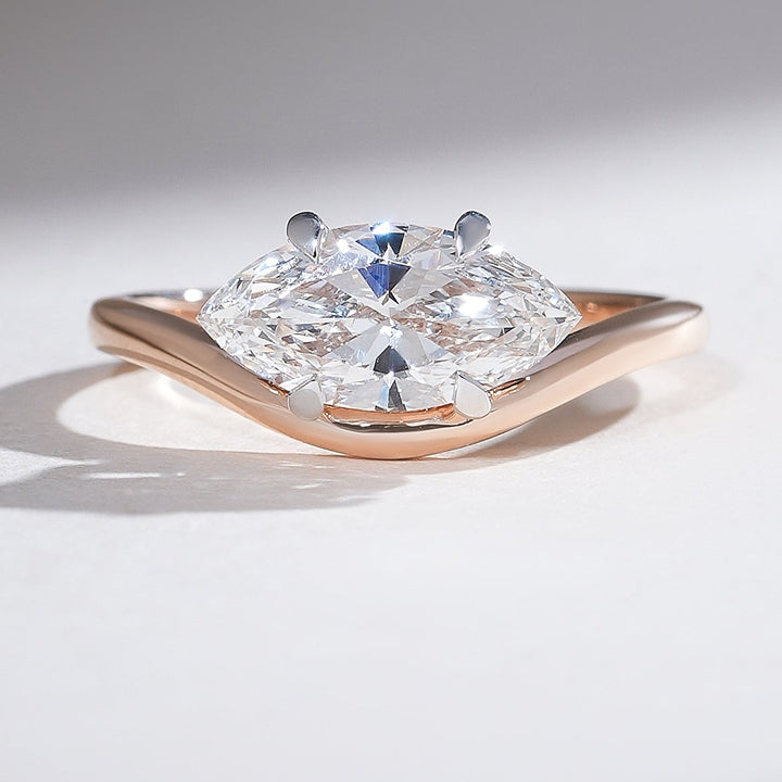 Close-up of the Aveline Marquise Solitaire Ring showcasing a marquise-cut diamond set in a rose gold band with a subtle wave design.