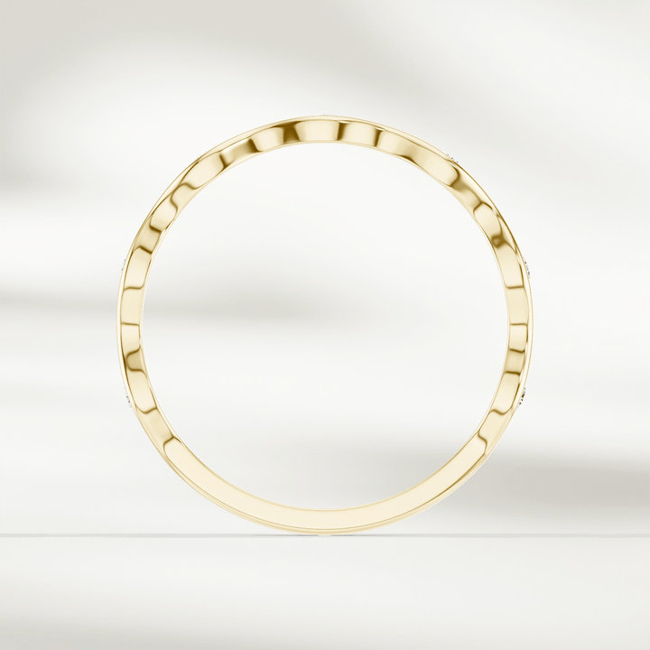 Top-down view of slim wavy diamond band ring in yellow gold