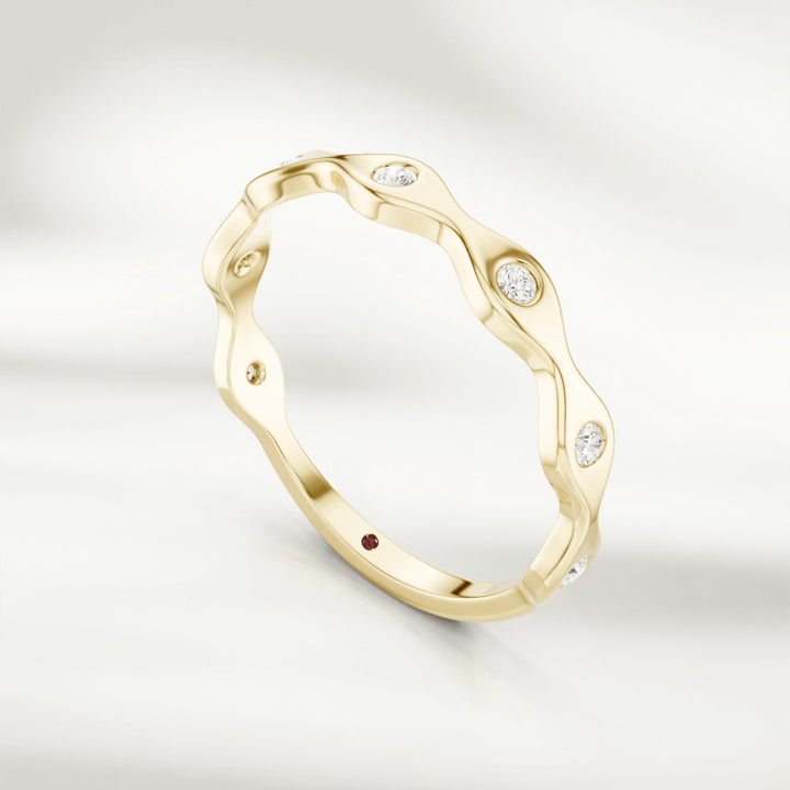 Yellow gold wavy diamond band ring with alternating curves and bezel-set stones