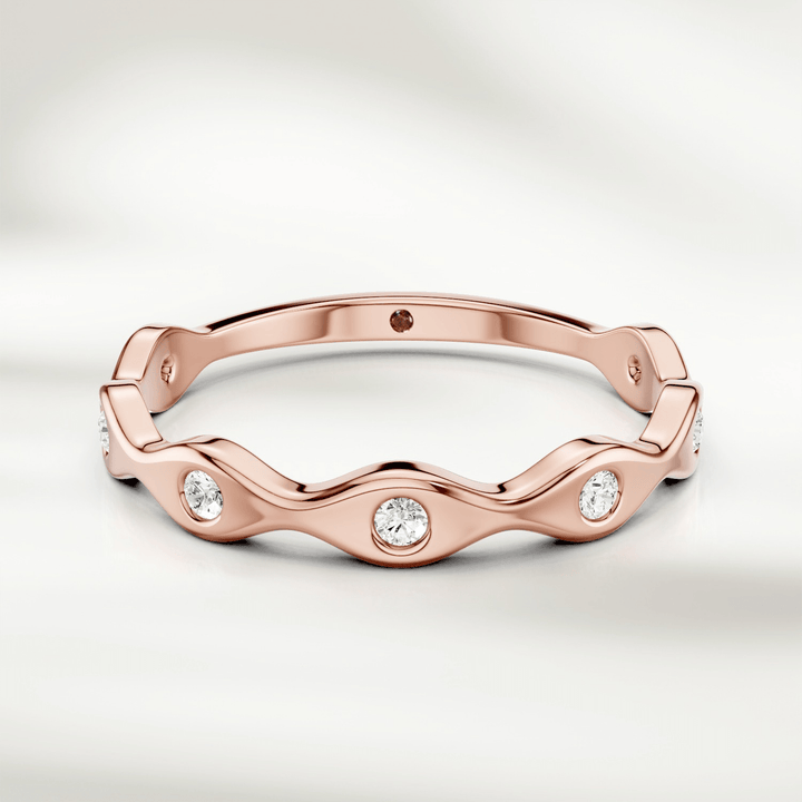 Top-down view of slim wavy diamond band ring in yellow gold
