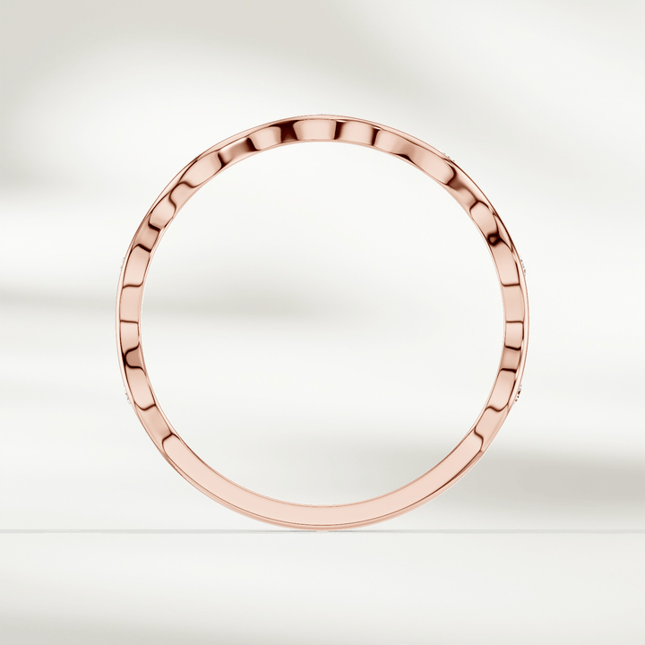 Top-down view of slim wavy diamond band ring in yellow gold