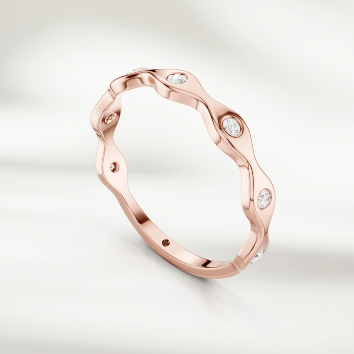 Yellow gold wavy diamond band ring with alternating curves and bezel-set stones