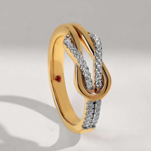Gold ring with diamond accents on a light gray background