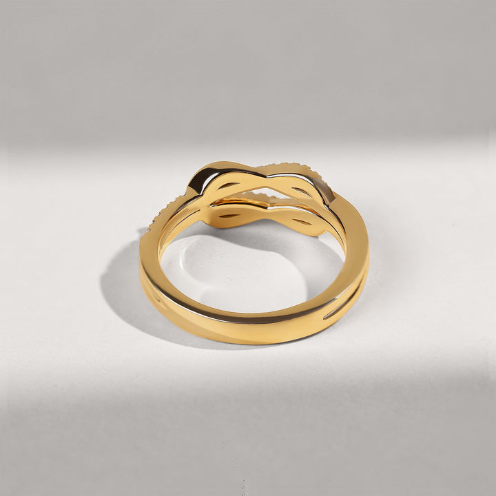 Gold ring with a unique design on a light gray background