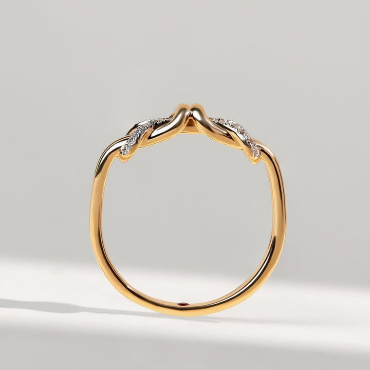Gold ring with diamond accents on a light gray background
