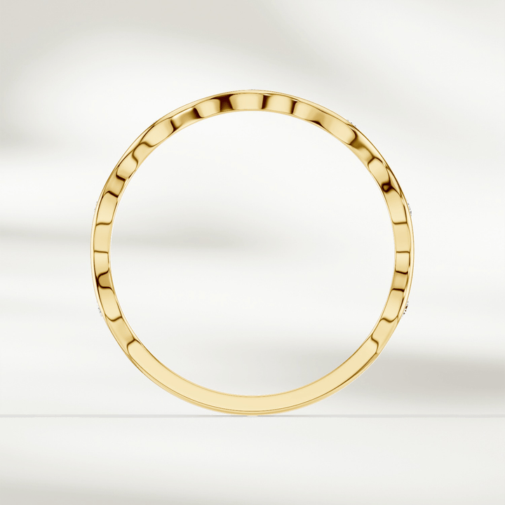 Top-down view of slim wavy diamond band ring in yellow gold