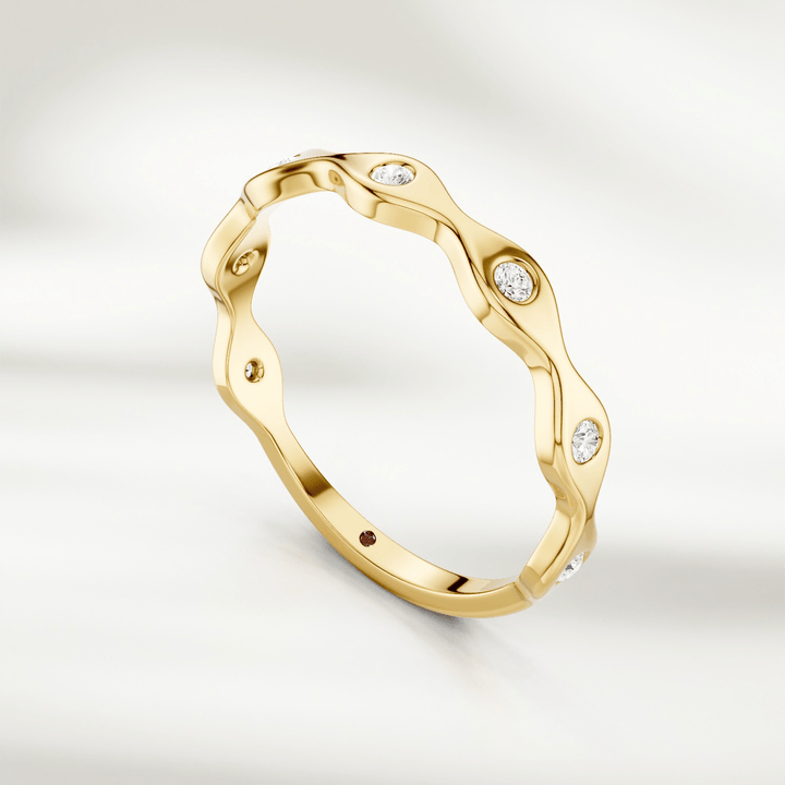 Yellow gold wavy diamond band ring with alternating curves and bezel-set stones