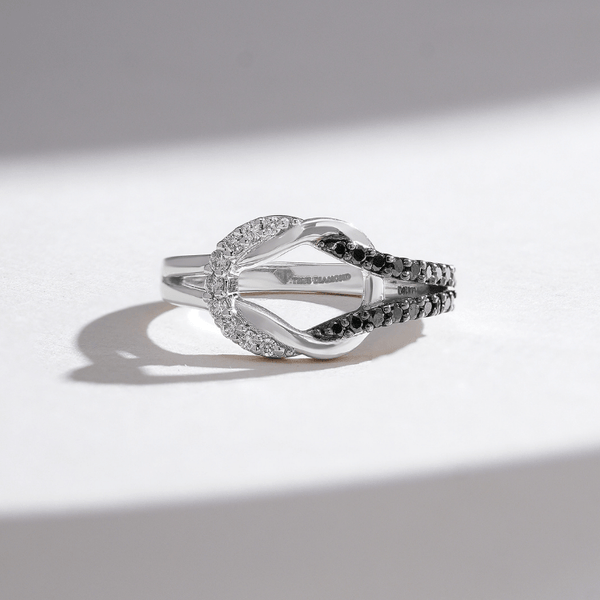 White gold split shank ring with a curved pavé of black and white diamonds, creating a bold contrast design.