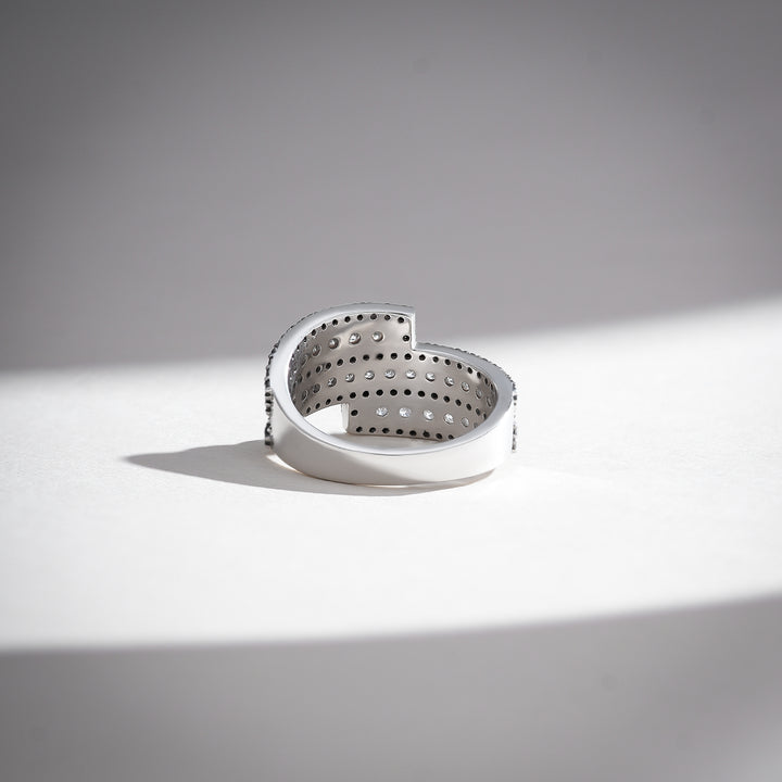 Back view of spiral white gold ring with open gallery and precision-set black diamonds along the edges.