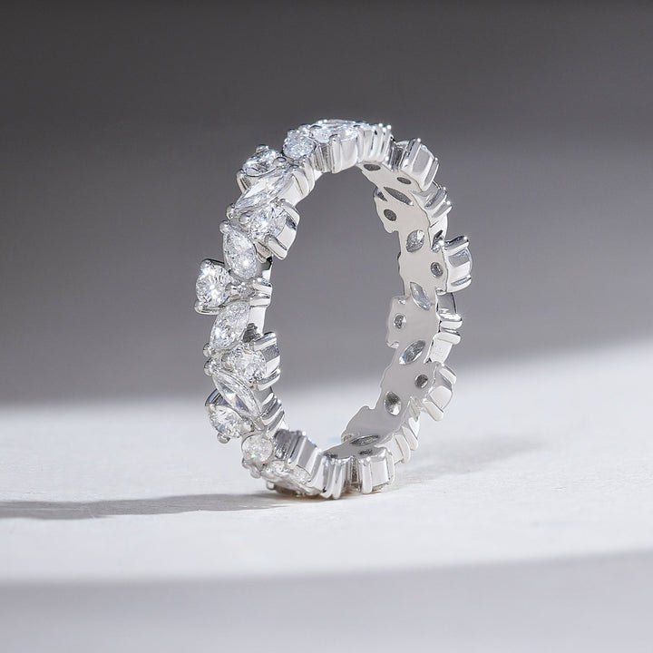 Side-standing view of white gold eternity ring with marquise and round diamonds set in a seamless eternity design.