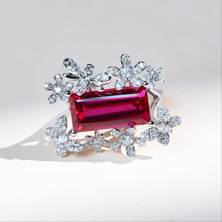 Front view of Crimson Fleur ruby cocktail ring framed by diamond flowers in white gold