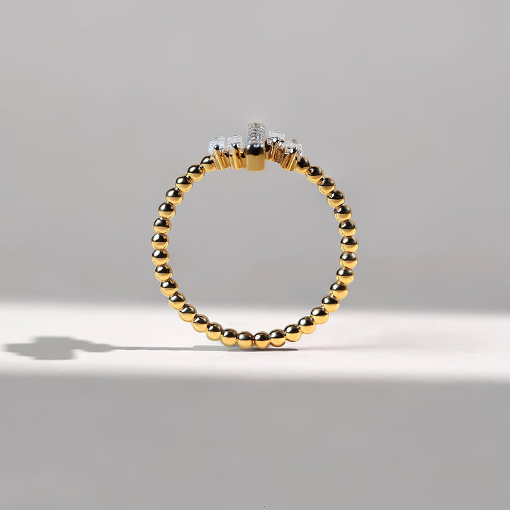 Front upright view of gold beaded band with diamonds aligned at the top.