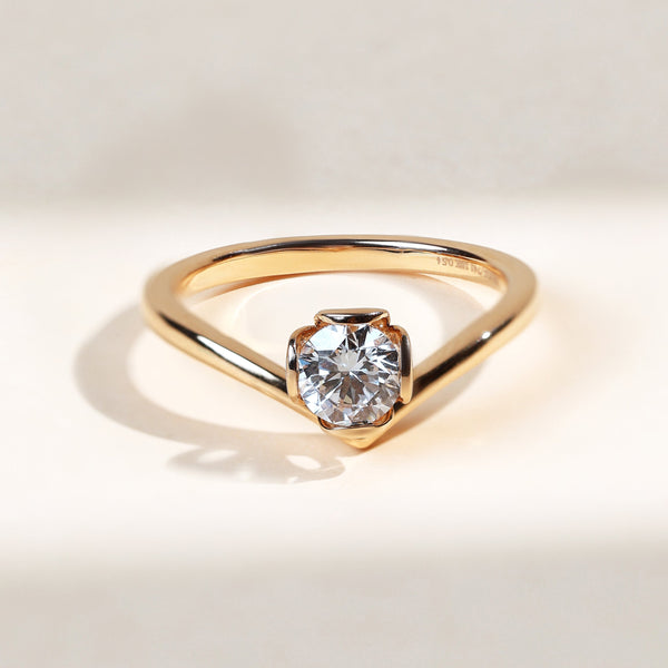Close-up of Elowen Petal 0.5 Ct round solitaire ring in yellow gold with petal-shaped prongs.