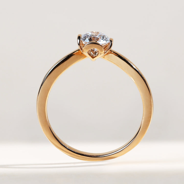Side profile of solitaire ring in yellow gold with a round diamond centerpiece.