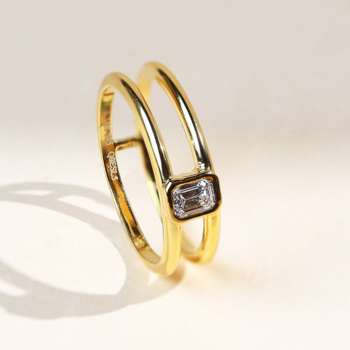 0.2 Ct Emerald Bezel Ring angled view showcasing dual gold band and bezel diamond