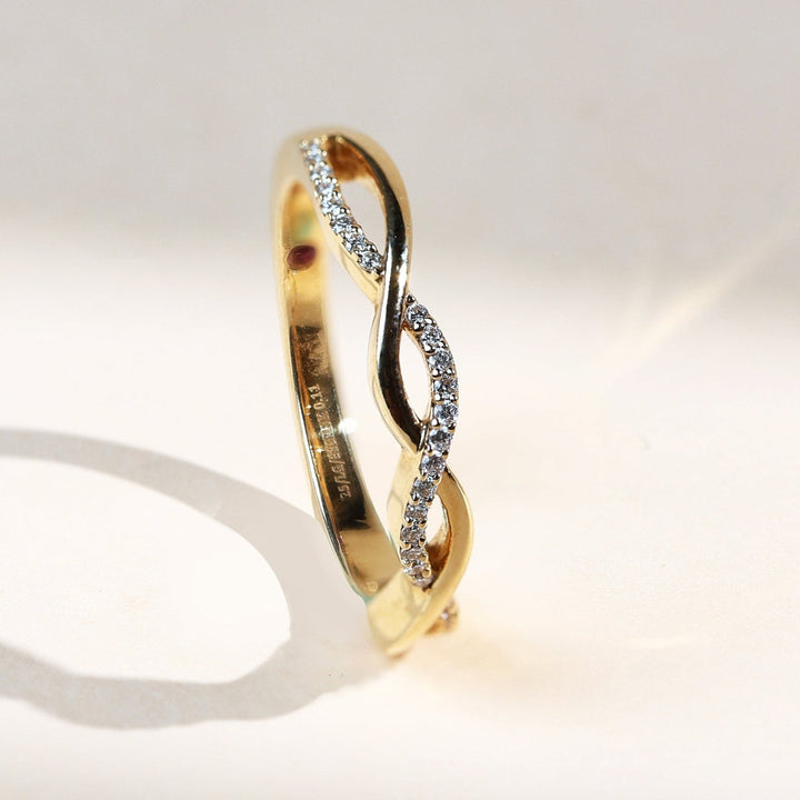 Side view of Entwined Promise Ring highlighting criss-cross design in gold with pavé diamonds