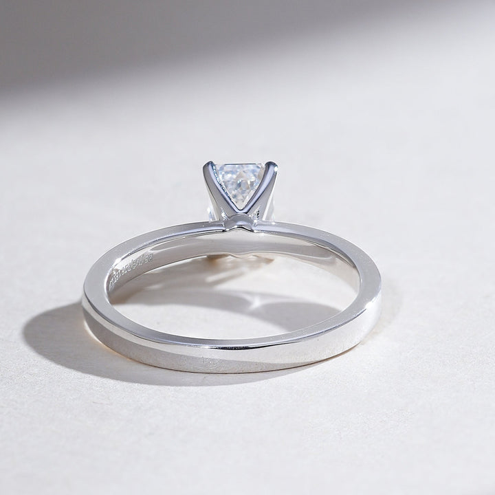 Back view highlighting the polished platinum shank of the emerald solitaire ring