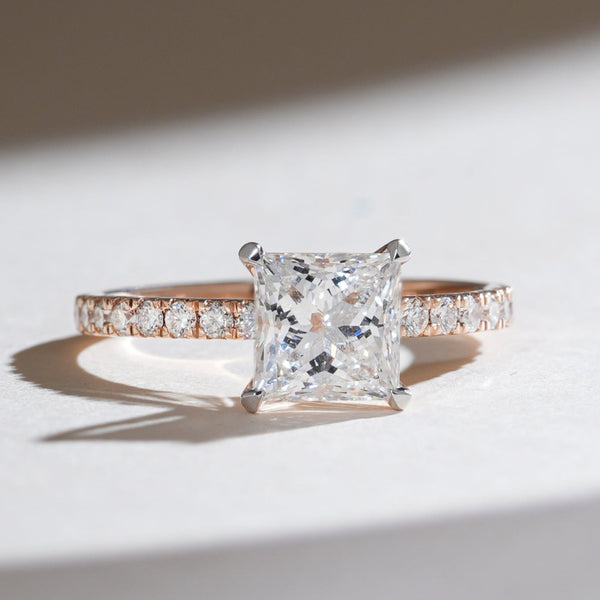 Front view of the Eternal Promise 1.5 Ct Princess Solitaire Ring with a brilliant princess-cut diamond on a rose gold band accented with pavé diamonds.