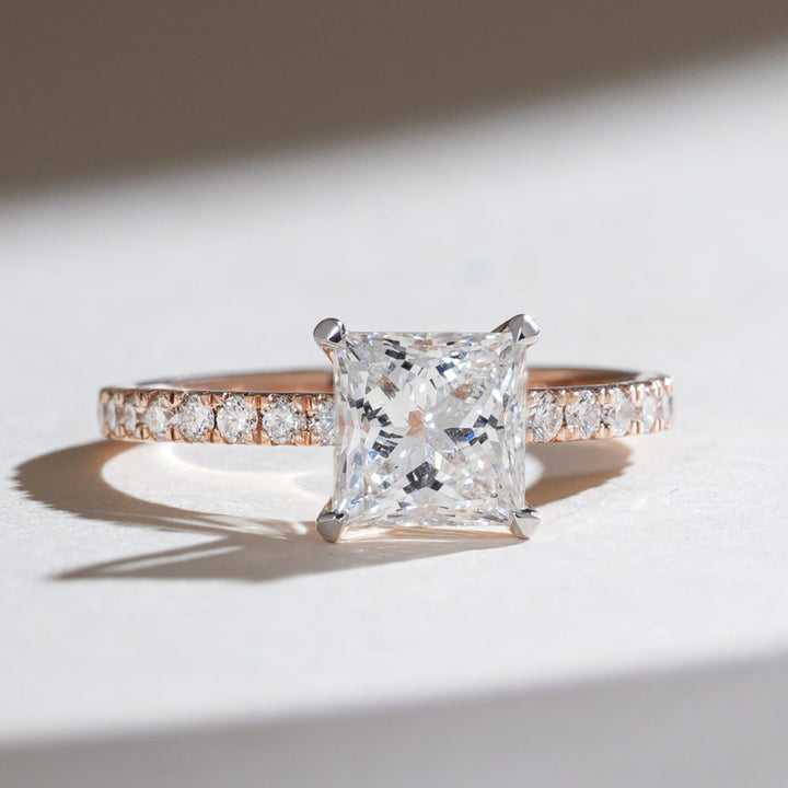 Front view of the Eternal Promise 1.5 Ct Princess Solitaire Ring with a brilliant princess-cut diamond on a rose gold band accented with pavé diamonds.