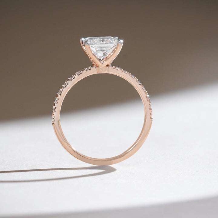 Profile view of the princess-cut solitaire ring showcasing the slim rose gold shank and the elevated diamond setting.