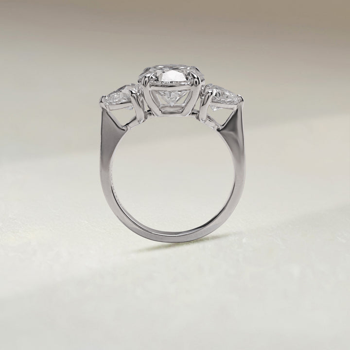 Upright angle of Evermore 3.5 Ct Three Stone Ring with round center and heart-shaped diamond accents in white gold.