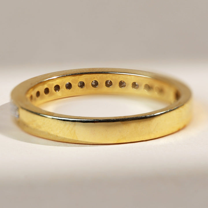 Back view of flat band eternity ring highlighting polished plain gold section.