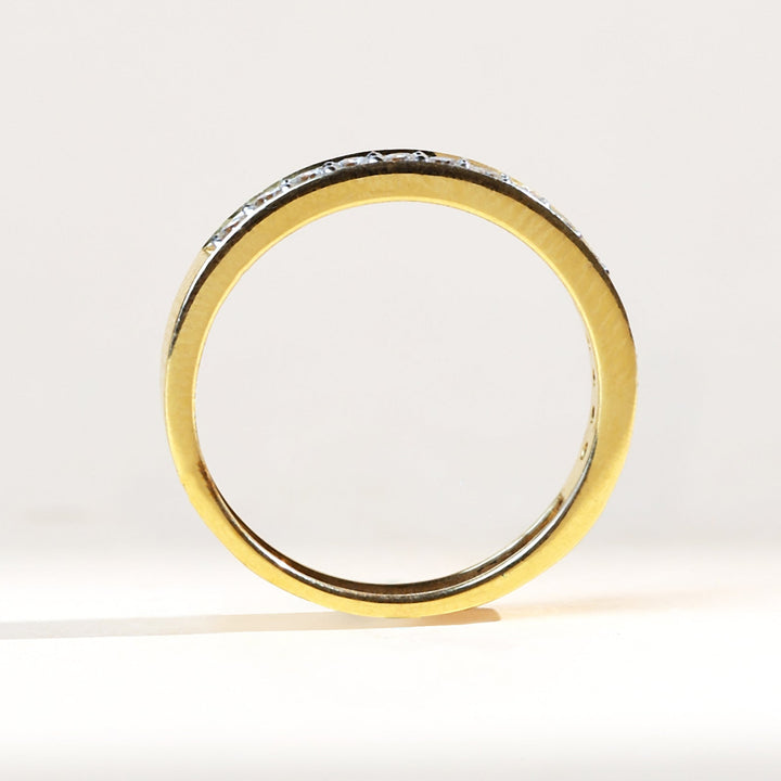 Profile view of flat band half eternity ring with diamond row across the top