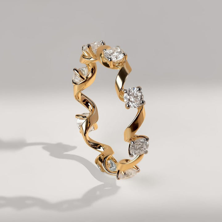 Angled shot highlighting the twisted gold vine with diamonds set around the band.