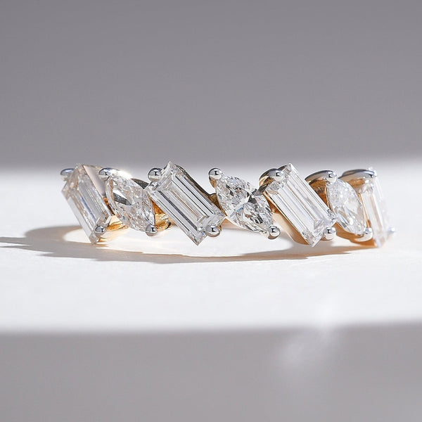 Close-up of half-eternity band with alternating marquise and baguette diamonds set in yellow gold.