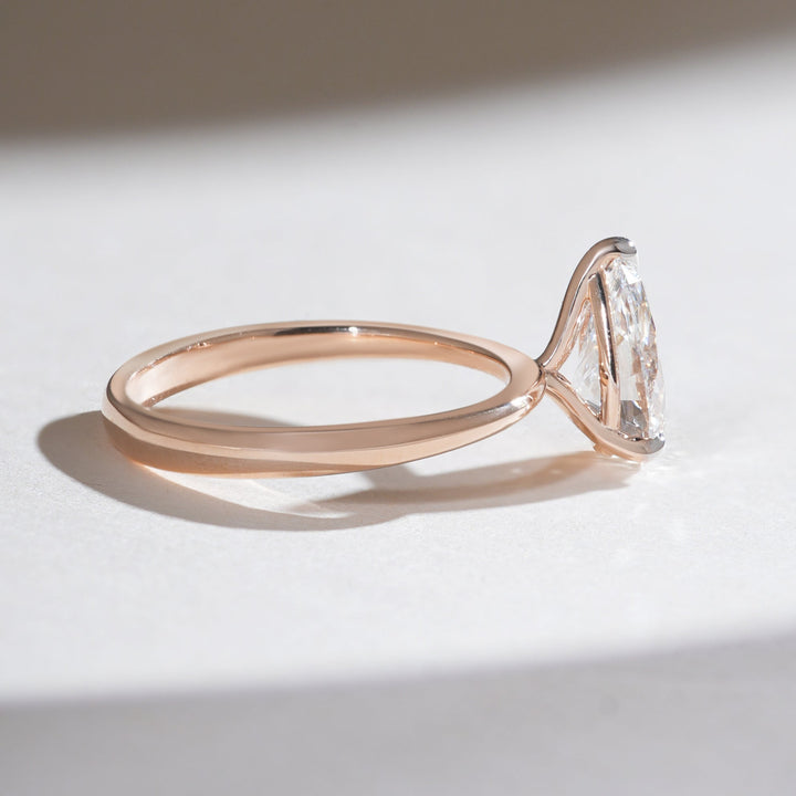 Side angle of the Iconic 1.5 Ct Pear Solitaire Ring showcasing the sleek rose gold band