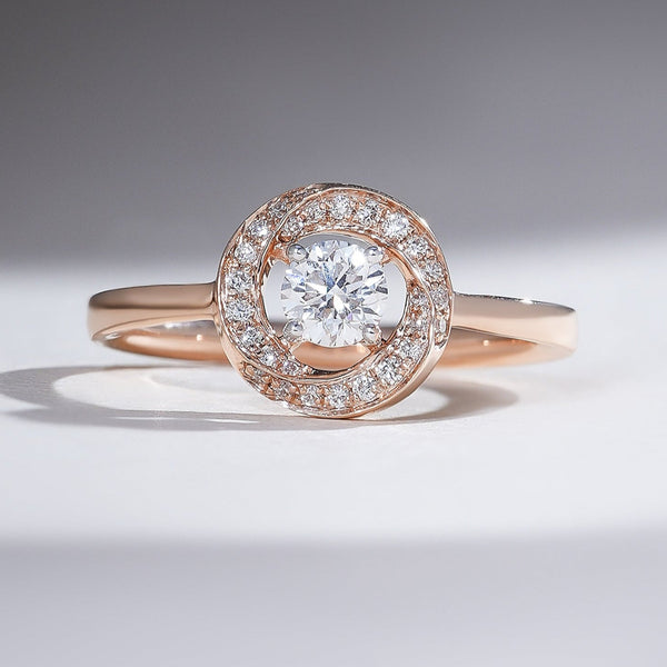 Rose-gold halo solitaire ring with a 0.3-ct round center diamond and pavé halo on a slim band.
