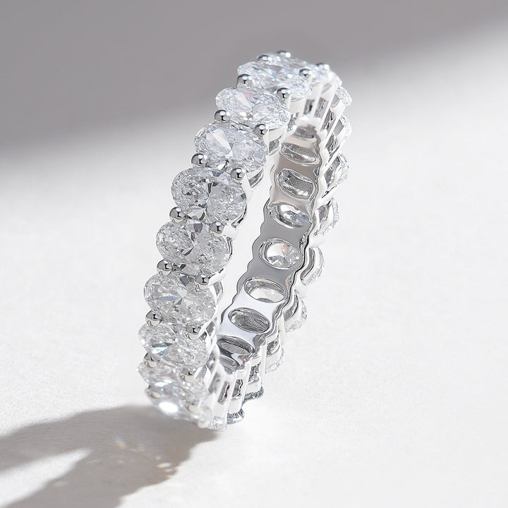 Standing profile of white gold eternity band set with oval-cut diamonds in a seamless design.