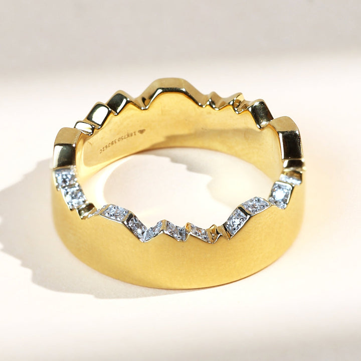 Profile view of geometric diamond-studded gold ring, showing full circular form.