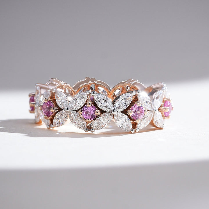 Front view of the Pink Dahlia Eternity Band with alternating marquise-cut diamonds and pink sapphires in a floral pattern on rose gold.